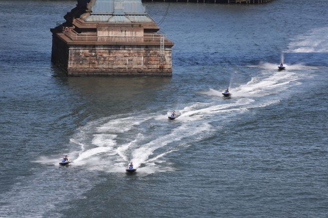 Water skiers in the East River, by the Manhattan Bridge anchorage